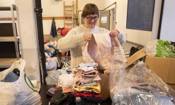GIVENDE ARBEID: Kristin Sundgot Ottesen bretter og sorterer barneklær.