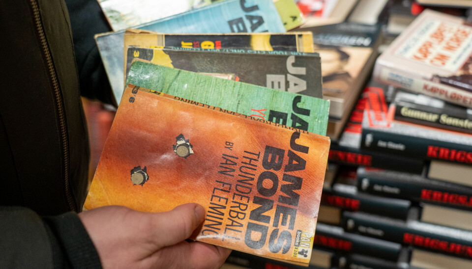GAMLE TEKSTER: Nederst i butikken, i en mørk kjeller, finner Geir Hovind Frøysedal fram de gamle James Bond-bøkene. Ian Fleming skrev 14 James Bond-bøker, den første kom ut i 1953 og het Casino Royal.