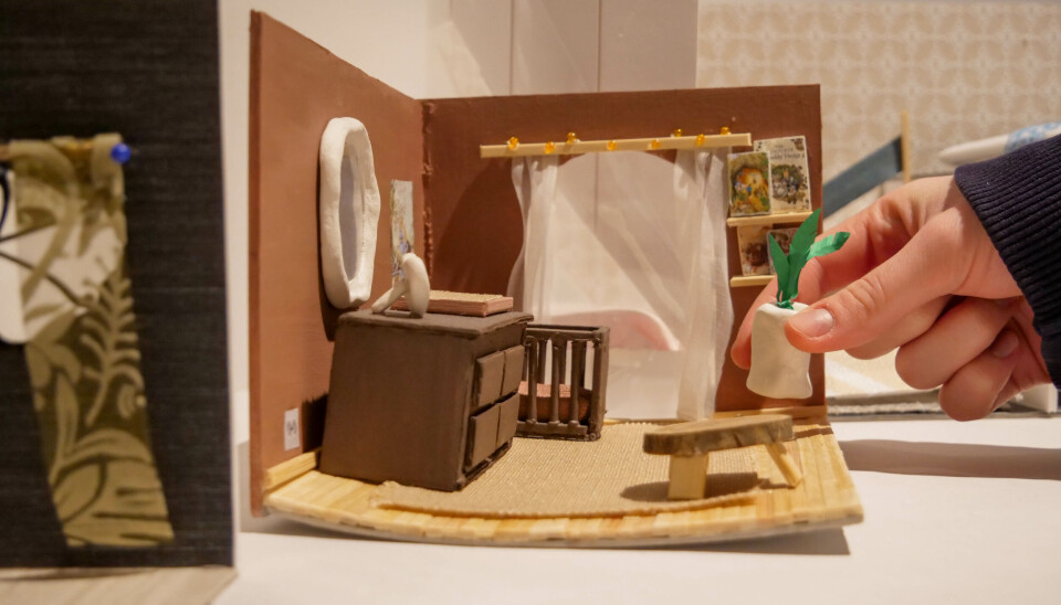 MINIATYRHUS: En av elevene plasserer liv i miniatyrhjemmet.