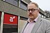 Odd Helge Mjellem Tonheim står framfor ein bygning med eit raudt skilt.